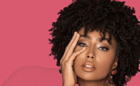 Woman with styled hair against a pink background