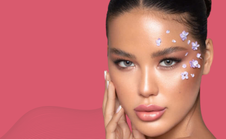 Woman with floral makeup on a pink background