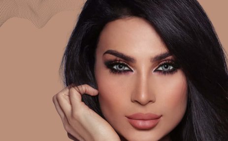 Woman with dark hair and makeup against a beige background
