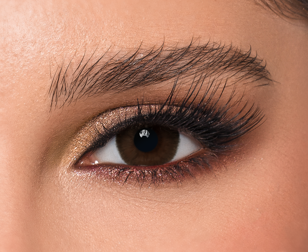 Lava DYE Contact Lenses, Close-up of eye wearing Lava DYE contact lens, deep natural brown color, daily wear, subtle makeup with shimmer eyeshadow and long lashes